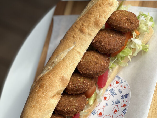 Falafel-Sandwich mit frischem Gemüse in einem knusprigen Brötchen, serviert bei MMK.